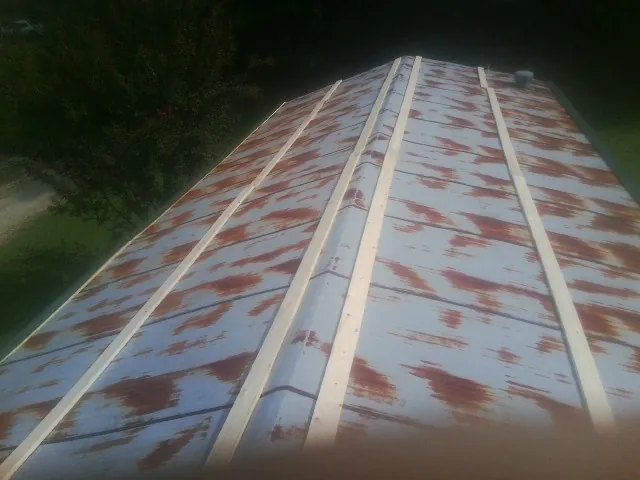 Rusted metal roof panels with new wood purlins before replacement — Storm Damage Roof Repair in Luling by Roofing Brothers