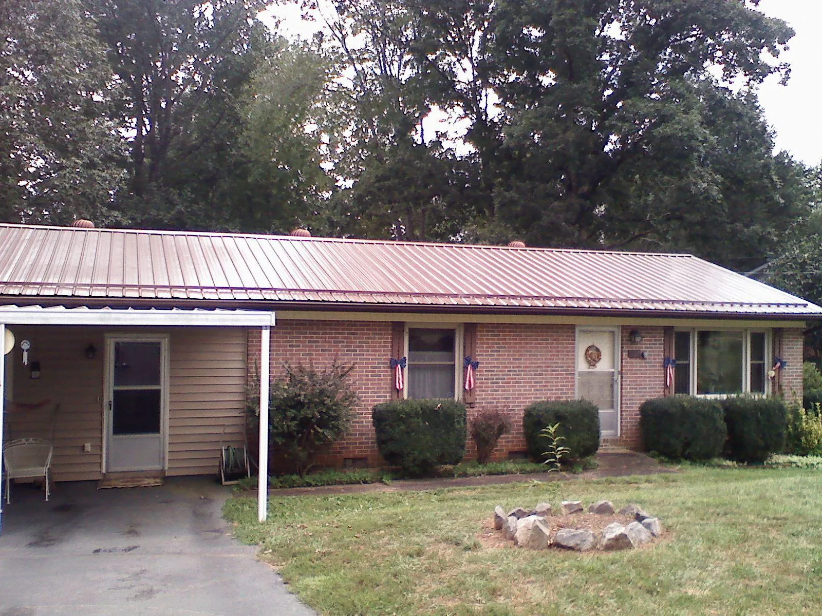 Bronze metal roof and carport on a brick ranch home — Roof Repair work by our crew in Luling