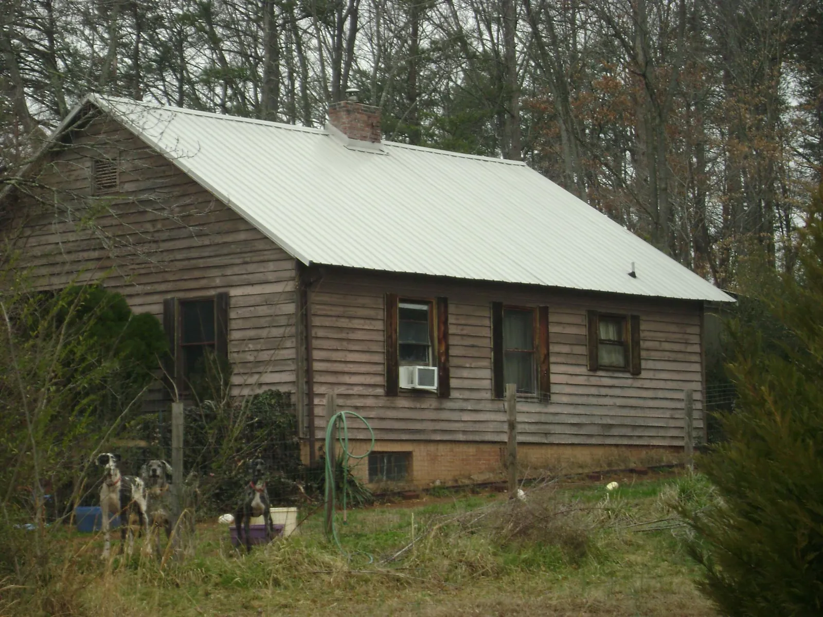 White metal roof on an old wood sided farmhouse, from a Asphalt Shingle Roof Repair job in Luling